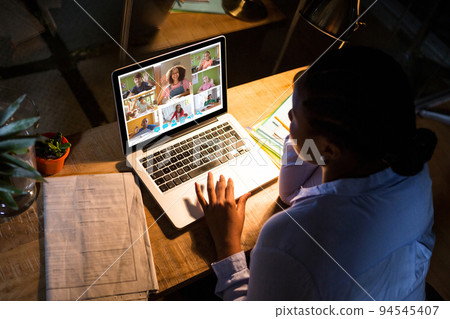 African american woman using laptop for video call, with diverse elementary school pupils on screen African american woman using laptop for video call, with diverse elementary school pupils on screen 94545407