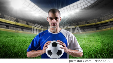 Composition of male football player holding football over sports stadium Composition of male football player holding football over sports stadium 94546509