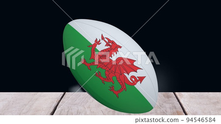 Composition of rugby ball decorated with the flag of wales on black background 94546584