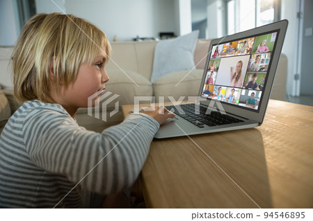 Caucasian boy using laptop for video call, with smiling diverse elementary school pupils on screen Caucasian boy using laptop for video call, with smiling diverse elementary school pupils on screen 94546895