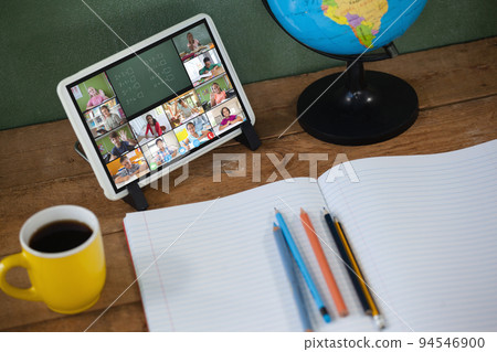 Smiling diverse elementary school pupils during class on tablet screen Smiling diverse elementary school pupils during class on tablet screen 94546900