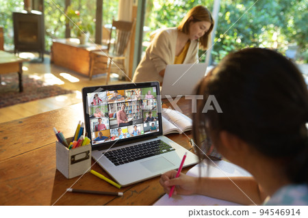 Asian girl using laptop for video call, with smiling diverse elementary school pupils on screen Asian girl using laptop for video call, with smiling diverse elementary school pupils on screen 94546914