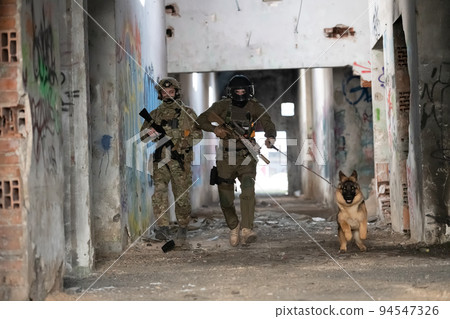 Modern Warfare Soldiers with military working dog in action on the battlefield.  94547326