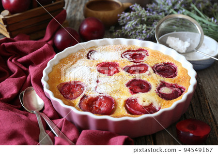 Red plums clafoutis (flan), icing sugar dressing, french cuisine Red plums clafoutis (flan), icing sugar dressing, french cuisine 94549167