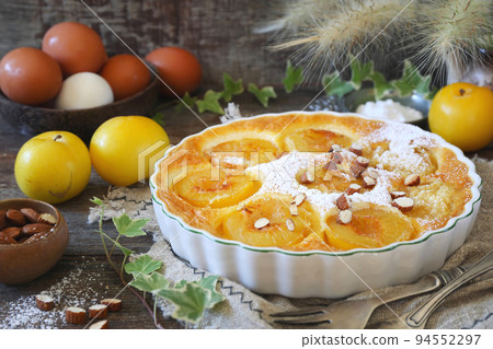 Yellow plums clafoutis (flan) with almonds, icing sugar dressing, french cuisine 94552297