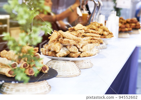 Bar counter with plates of sausages, croquettes and pasties and blur effect Bar counter with plates of sausages, croquettes and pasties and blur effect 94552602