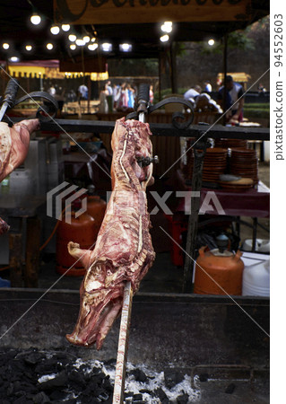 View of the preparation of a pig on a restaurant grill View of the preparation of a pig on a restaurant grill 94552603