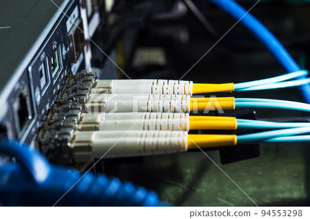 Selective focus fiber optic cables are plugged into the back panal of the server. 94553298
