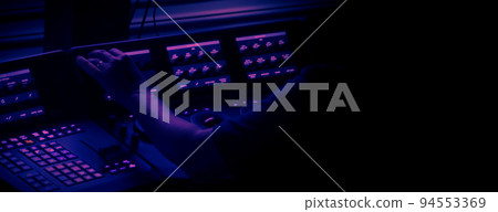 Edit video production control panel in studio. Editor editing and grade film in movie post room. Telecine control machine and man hand editing or adjusting color on digital video in post production. 94553369