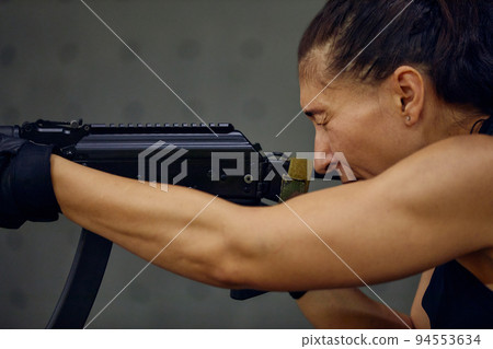 A military girl takes aim while sitting. Women's Army 94553634