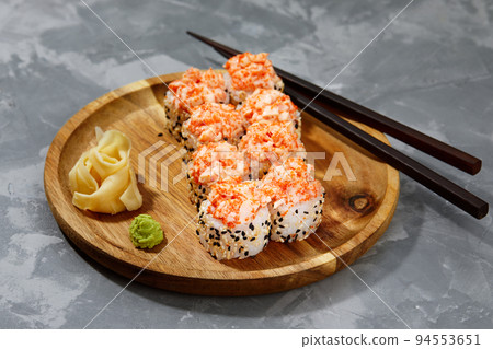 Warm rolls with tuna, salmon, perch, eel, tobiko caviar, nori, rice, cucumber on a black background. Warm rolls with tuna, salmon, perch, eel, tobiko caviar, nori, rice, cucumber on a black background. 94553651