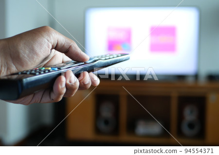 close up of man hand holding tv remote. close up of man hand holding tv remote. 94554371