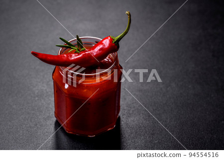 Glass jar with homemade classic spicy tomato pasta or pizza sauce with spices and herbs 94554516
