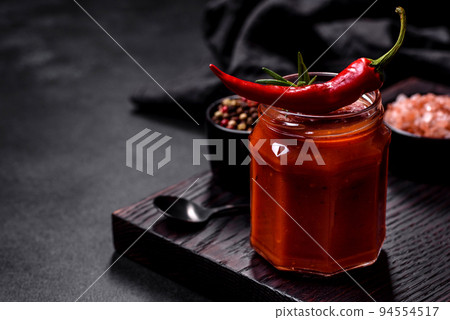 Glass jar with homemade classic spicy tomato pasta or pizza sauce with spices and herbs 94554517