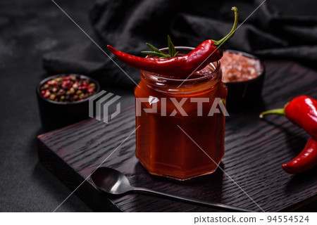 Glass jar with homemade classic spicy tomato pasta or pizza sauce with spices and herbs Glass jar with homemade classic spicy tomato pasta or pizza sauce with spices and herbs 94554524