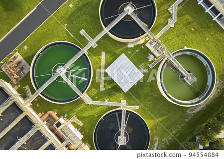 Aerial view of modern water cleaning facility at urban wastewater treatment plant. Purification process of removing undesirable chemicals, suspended solids and gases from contaminated liquid Aerial view of modern water cleaning facility at urban wastewater treatment plant. Purification process of removing undesirable chemicals, suspended solids and gases from contaminated liquid 94554884