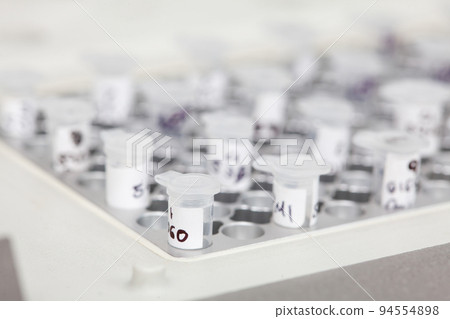 Closeup of test tubes at a thermal cycler block in a molecular biology laboratory. Polymerase chain reaction technique. PCR technique 94554898