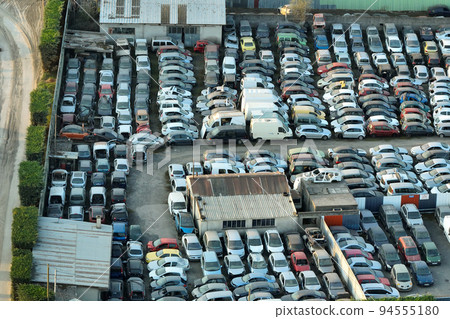 Aerial view of big parking lot of junkyard with rows of discarded broken cars. Recycling of old vehicles 94555180