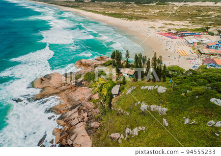 Popular Joaquina Beach with rocks and ocean with waves in Brazil. Aerial view 94555233