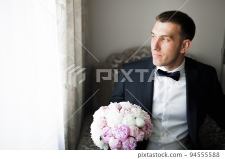 Grooms morning preparation. Handsome man getting dressed and preparing for the wedding Grooms morning preparation. Handsome man getting dressed and preparing for the wedding 94555588