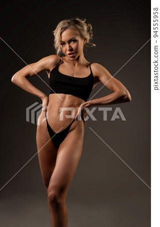 Alluring woman in black underwear standing on dark backgorund Alluring woman in black underwear standing on dark backgorund 94555958