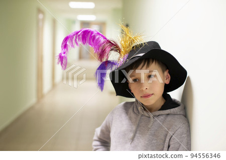 Little boy in a theater hat with feathers. Young artist from the theater studio. 94556346