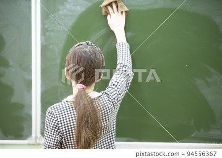 A middle school or junior high school student wipes the blackboard. A middle school or junior high school student wipes the blackboard. 94556367