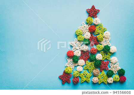 Christmas tree made from colored handmade ball decoration on colored background, view from above. New Year minimal concept with copy space Christmas tree made from colored handmade ball decoration on colored background, view from above. New Year minimal concept with copy space 94556608