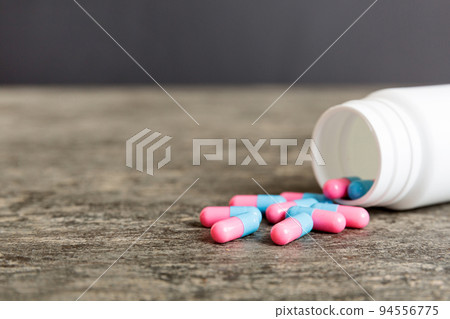 plastic medicine bottle with capsules of pills on colored background. Online pharmacy. Painkiller medicine and antibiotic drug resistance concept. Pharmaceutical industry 94556775