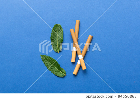 Menthol cigarettes and fresh mint leaves on colored background, Many cigarettes stacked together top view flat lay 94556865