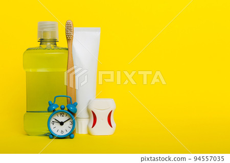 Mouthwash and other oral hygiene products on colored table top view with copy space. Flat lay. Dental hygiene. Oral care products and space for text on light background. concept Mouthwash and other oral hygiene products on colored table top view with copy space. Flat lay. Dental hygiene. Oral care products and space for text on light background. concept 94557035
