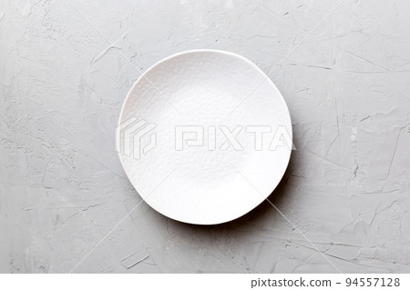 Top view of empty light plate on cement background. Empty space for your design Top view of empty light plate on cement background. Empty space for your design 94557128