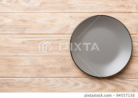 Top view of empty grey plate on wooden background. Empty space for your design Top view of empty grey plate on wooden background. Empty space for your design 94557138