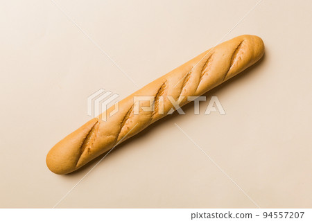 Minimalist french baguette on colored background. fresh bread as background, top view with space for your text or design Minimalist french baguette on colored background. fresh bread as background, top view with space for your text or design 94557207