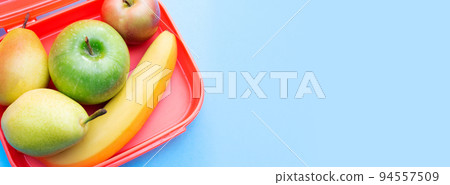 Banner with lunch box with fruits. Useful snack. Top view. Copy space. Blue background. Place for text. 94557509