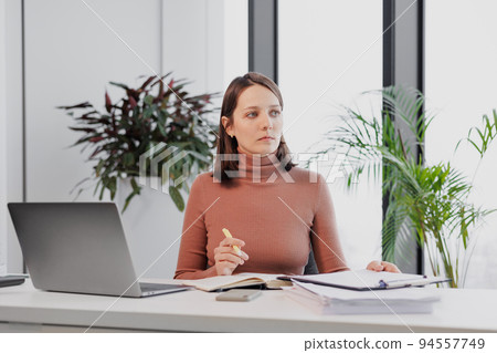 business and finance, a female entrepreneur in the office working with a laptop. a successful European woman financier marketer checks the counter business and finance, a female entrepreneur in the office working with a laptop. a successful European woman financier marketer checks the counter 94557749