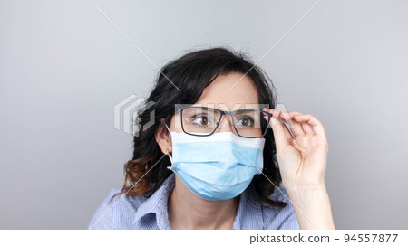 Woman wearing protection face mask against coronavirus. Woman in a mask and glasses. 94557877