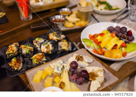 Dinner table with snacks decorated with beautiful summer flowers. Food Table Healthy Delicious Organic Meal Concept. Waiting for the guest. Dinner table with snacks decorated with beautiful summer flowers. Food Table Healthy Delicious Organic Meal Concept. Waiting for the guest. 94557920
