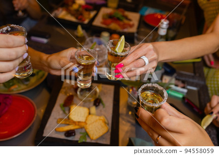 Clinking glasses with alcohol and toasting, party. 94558059