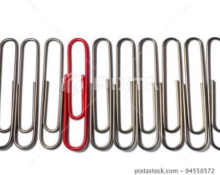 Metal paper clips on a white background. Office supplies isolate. Idea. The concept of loneliness. Confrontation. Stands out from the crowd. 94558572