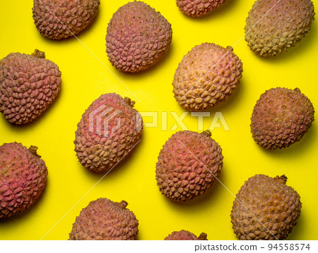Lychee on the table. Chinese plum on a yellow background. Ripe fruit from Asia. 94558574