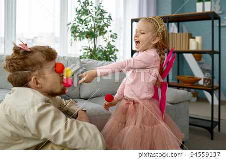Playful father and daughter enjoy game together Playful father and daughter enjoy game together 94559137