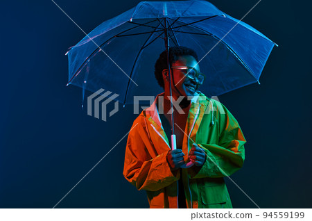 Hipster woman in raincoat with umbrella in neon light 94559199