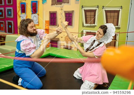 Funny man and woman fighting on toy ring 94559296