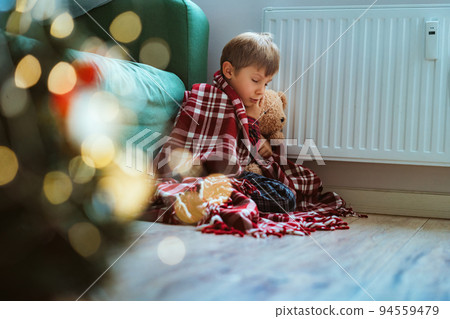 cute little boy wrapped id plaid sitting by heater cute little boy wrapped id plaid sitting by heater 94559479