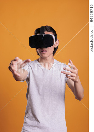 Man wearing vr headset playing virtual reality games in cyber space, enjoying simulation experience, exploring metaverse. Cyberspace entertainment, leisure activity, modern technology 94559716