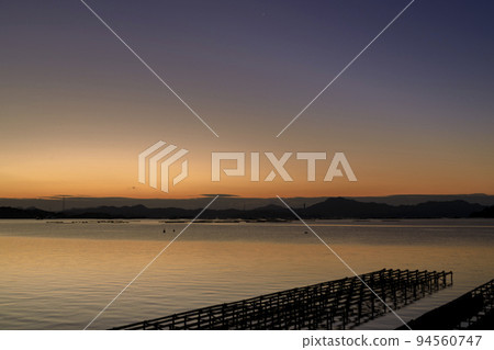 Winter in Setouchi Sunrise illuminates the sea lined with oyster shelves Winter in Setouchi Sunrise illuminates the sea lined with oyster shelves 94560747