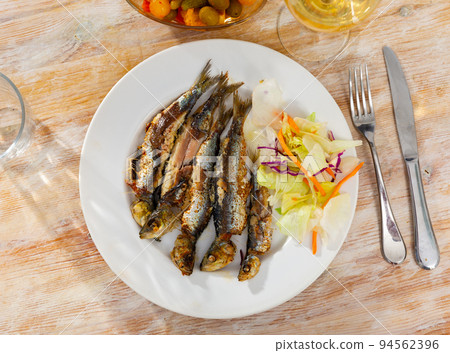 Grilled sardines served with fresh vegetable salad Grilled sardines served with fresh vegetable salad 94562396