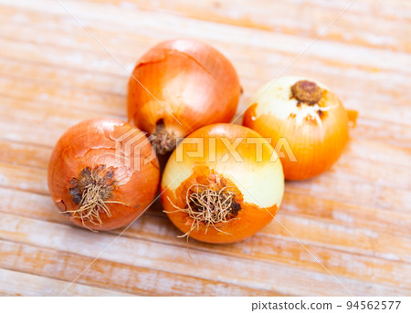 Close up photo of onions on wooden table Close up photo of onions on wooden table 94562577