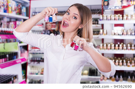 woman delighted with assortment of nail varnishes 94562690